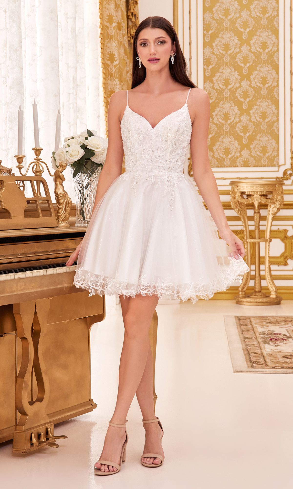 A woman in the Short Homecoming Dress CD0213 with embroidery and nude heels stands beside a gold piano in an ornate, gold-accented room.